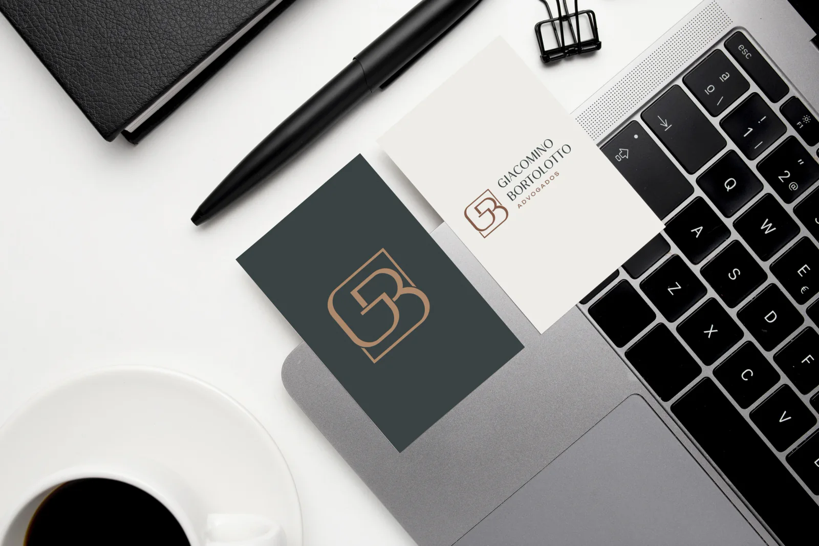 Materiais com a identidade visual Giacomino Bortolotto sobre uma mesa de trabalho